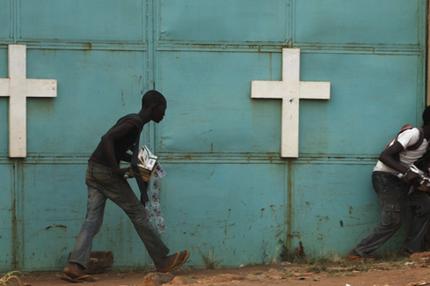 Menschen suchen bei einer Kirche Schutz vor Schüssen zwischen afrikanischen Friedenstruppen und christlichen Milizen.