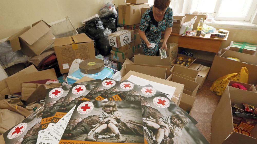 Eine Mitarbeiterin des Roten Kreuzes in Sibirien packt Hilfslieferungen für die Ukraine