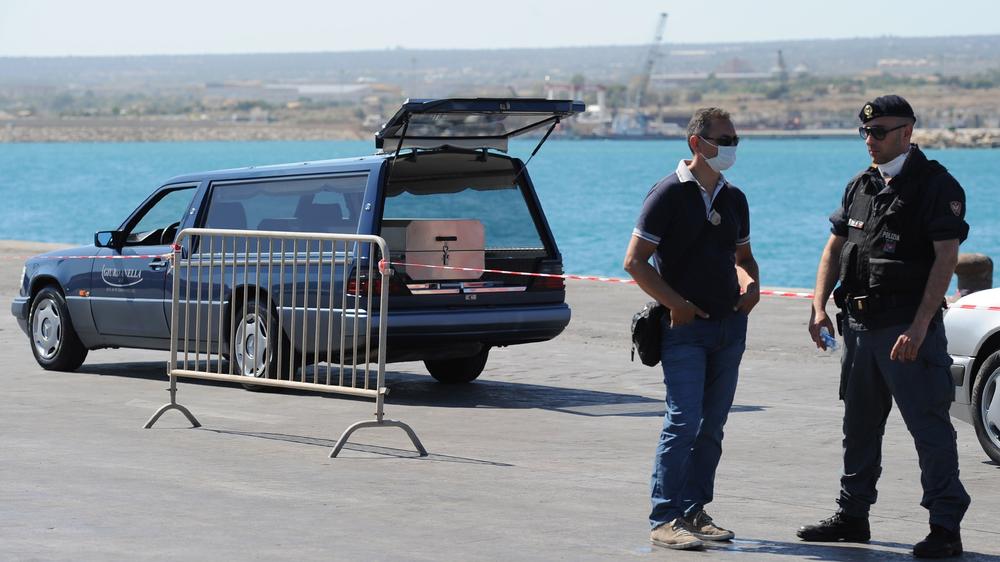 Mittelmeer: Polizisten auf Sizilien neben einem Leichenwagen mit dem Sarg eines getöteten Migranten