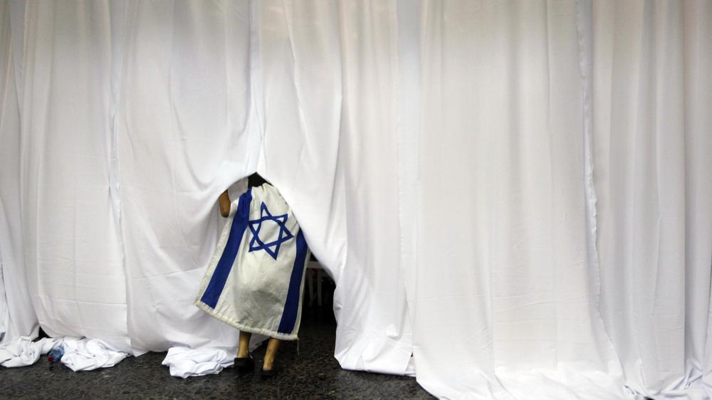 Eine Frau mit israelischer Flagge bei einer Willkommenszeremonie für Einwanderer aus den USA auf dem Flughafen von Tel Aviv