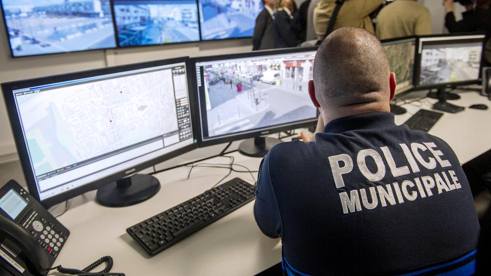 Ein französischer Polizist verfolgt Bilder von Überwachungskameras. 