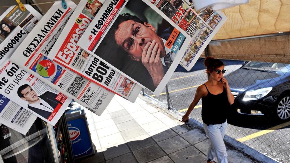 Referendum: A woman passes a newspaper kiosk with journal headlines showing the results of Greece's referendum, in Thessaloniki, on July 6, 2015. More than 61 percent of Greek voters rejected fresh austerity demands by the country's EU-IMF creditors in a historic referendum, official results from over 95 percent of polling stations showed. AFP PHOTO / SAKIS MITROLIDIS (Photo credit should read SAKIS MITROLIDIS/AFP/Getty Images)