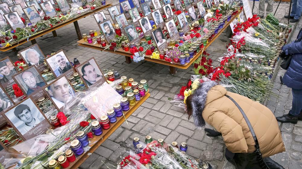 Ukraine: Am 20. Februar 2016, dem zweiten Jahrestag der Euromaidan-Revolution, legt eine Ukrainerin Blumen auf dem Maidan in Kiew ab. 