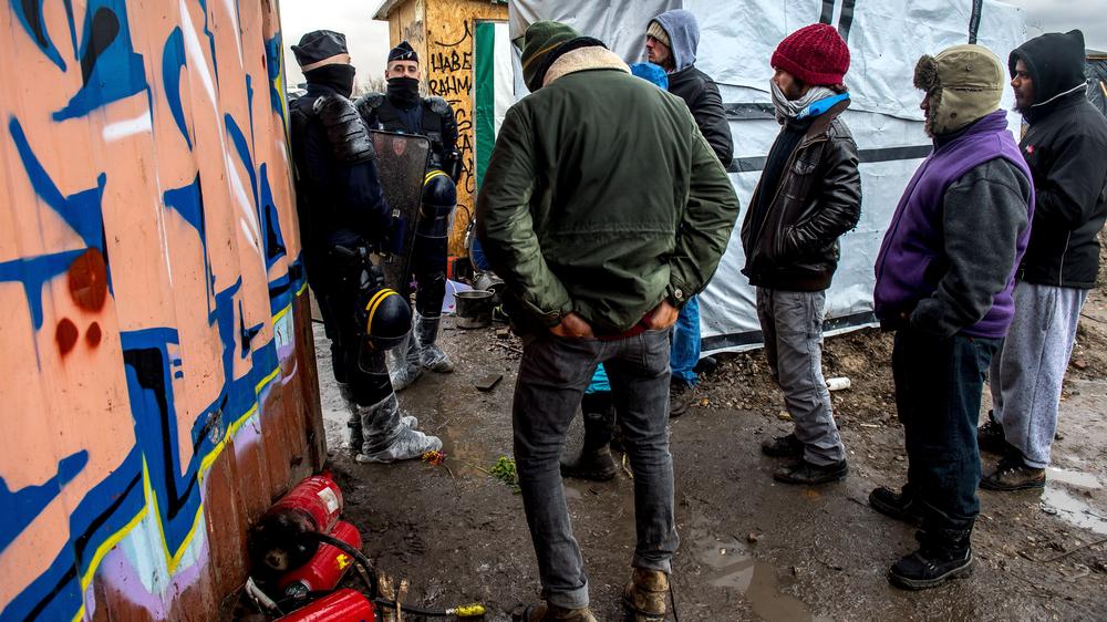 Brexit: Polizisten blockieren Flüchtlinge, während das Flüchtlingslager bei Calais geräumt wird. 