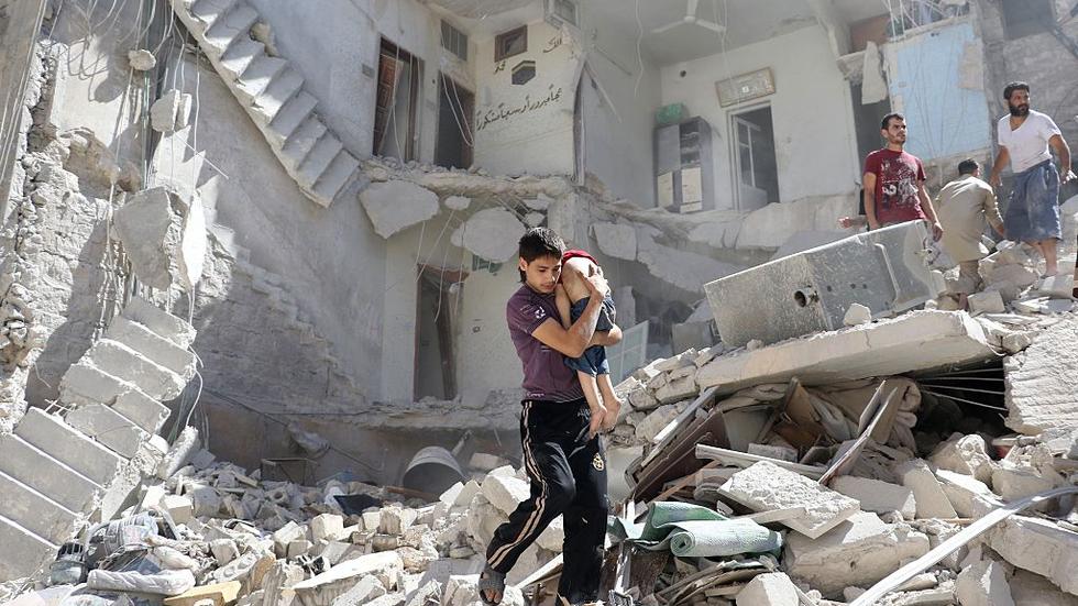 Aleppo: Ein Syrer rettet einen Jungen aus einem zerstörten Haus in Aleppo-Mashhad, das Ende Juli 2016 von einer Fassbombe getroffen wurde. 