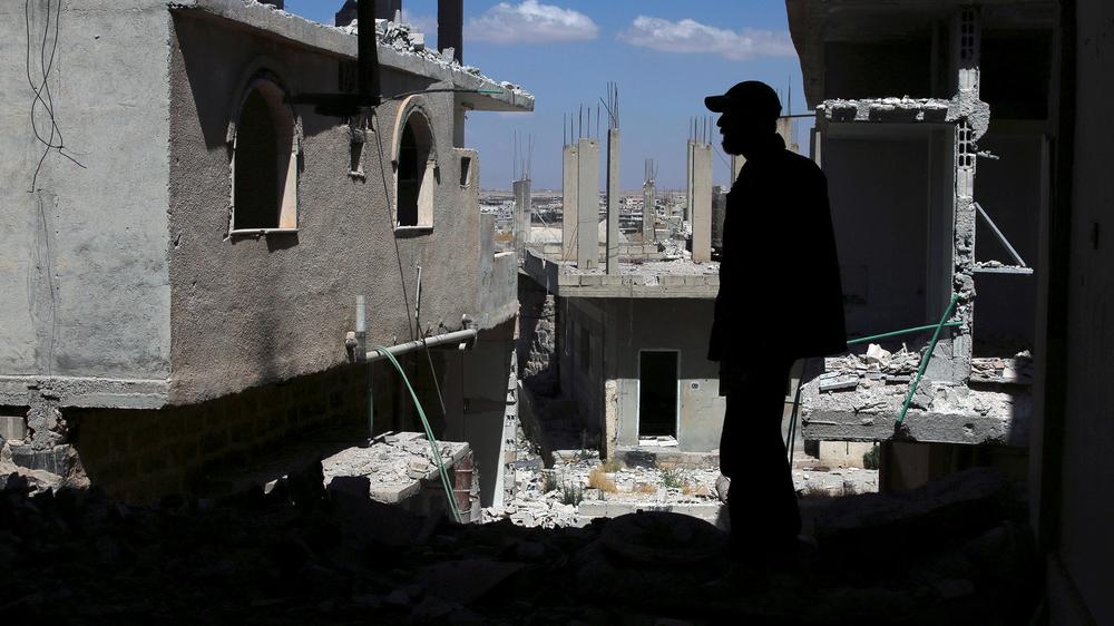 Ein Mann steht in einem vom Krieg zerstörten Haus im syrischen Deraa.