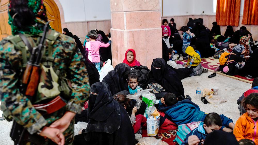 Syrien: Eine Kämpferin der Syrischen Demokratischen Kräfte steht zwischen Zivilisten, die aus dem Zentrum der syrischen Stadt Rakka geflüchtet sind.