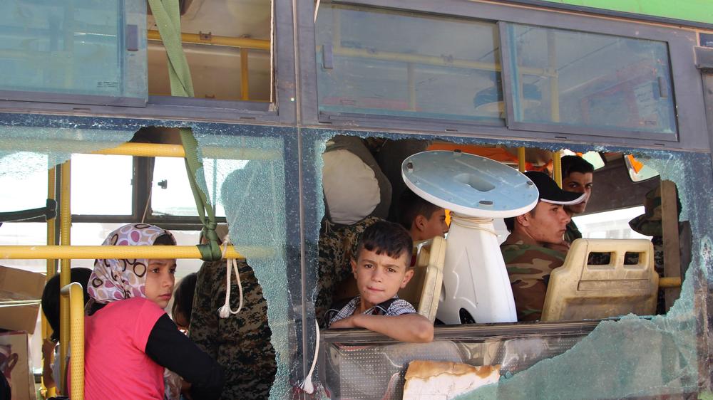 Krieg in Syrien: Evakuierte Zivilisten aus Al-Fu'ah und Kafriya in der Provinz Idlib schauen aus dem zerbrochenen Fenster eines Busses.