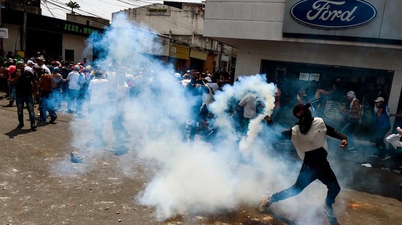 Venezuela: Gewaltsame Auseinandersetzung um Hilfstransporte: In San Antonio del Táchira, einer Stadt auf der venezolanischen Seite der Grenze zu Kolumbien, wirft ein Demonstrant einen Tränengaskanister zurück zu den Sicherheitskräften. 
