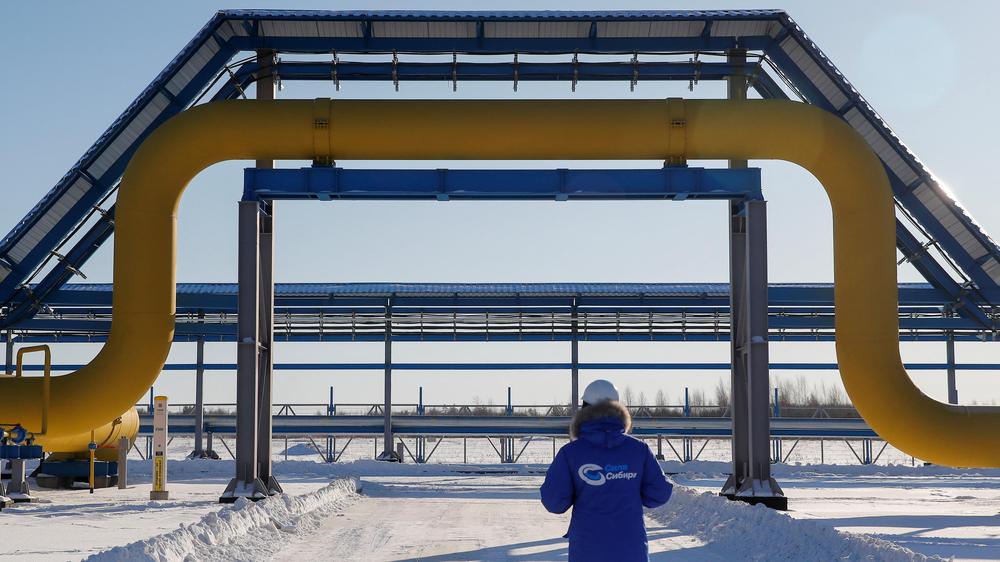 Überblick zum Ukraine-Krieg: Ein Mitarbeiter von Gazprom steht vor einer Pipeline in Russland.