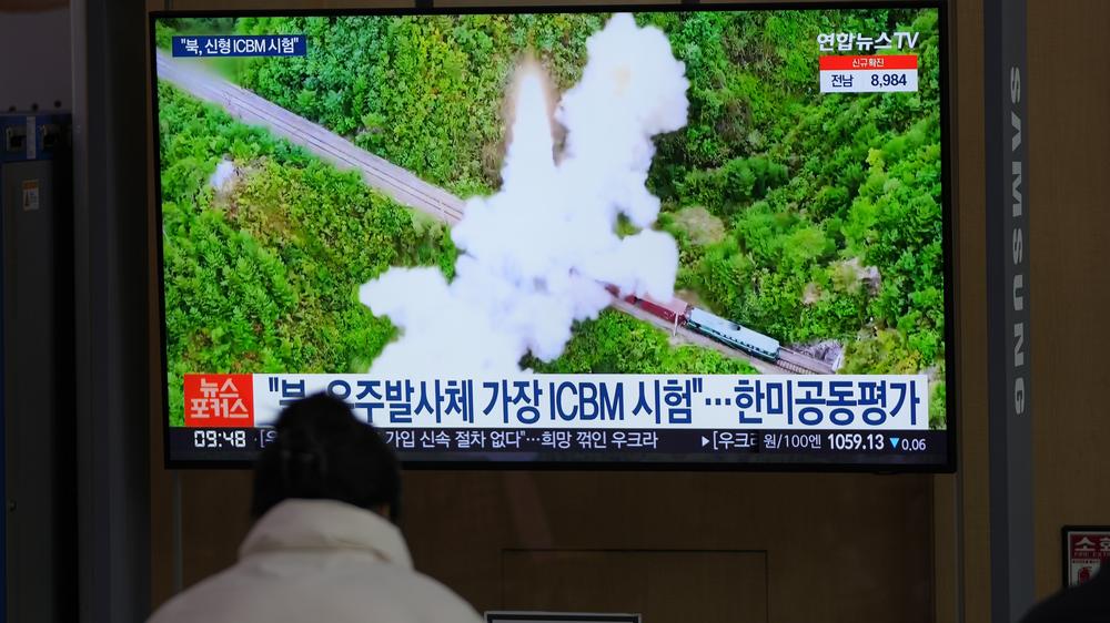 Waffentests: Eine Frau betrachtet einen Fernsehbildschirm in einem Bahnhof, auf dem eine Nachrichtensendung über Nordkoreas Raketen gezeigt wird.