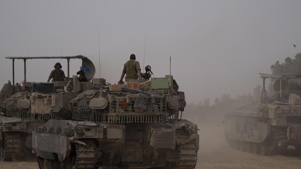 Gaza-Krieg: Israelische Soldaten stehen auf gepanzerten Fahrzeugen, die auf einem Gelände an der Grenze zwischen Israel und Gaza geparkt sind.