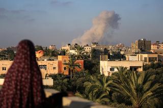 Eine palästinensische Frau beobachtet, wie nach einem israelischen Angriff südlich von Gaza-Stadt, in der Stadt Al-Zawaida im zentralen Gazastreifen, am 11. Juni 2024 Rauch aufsteigt.