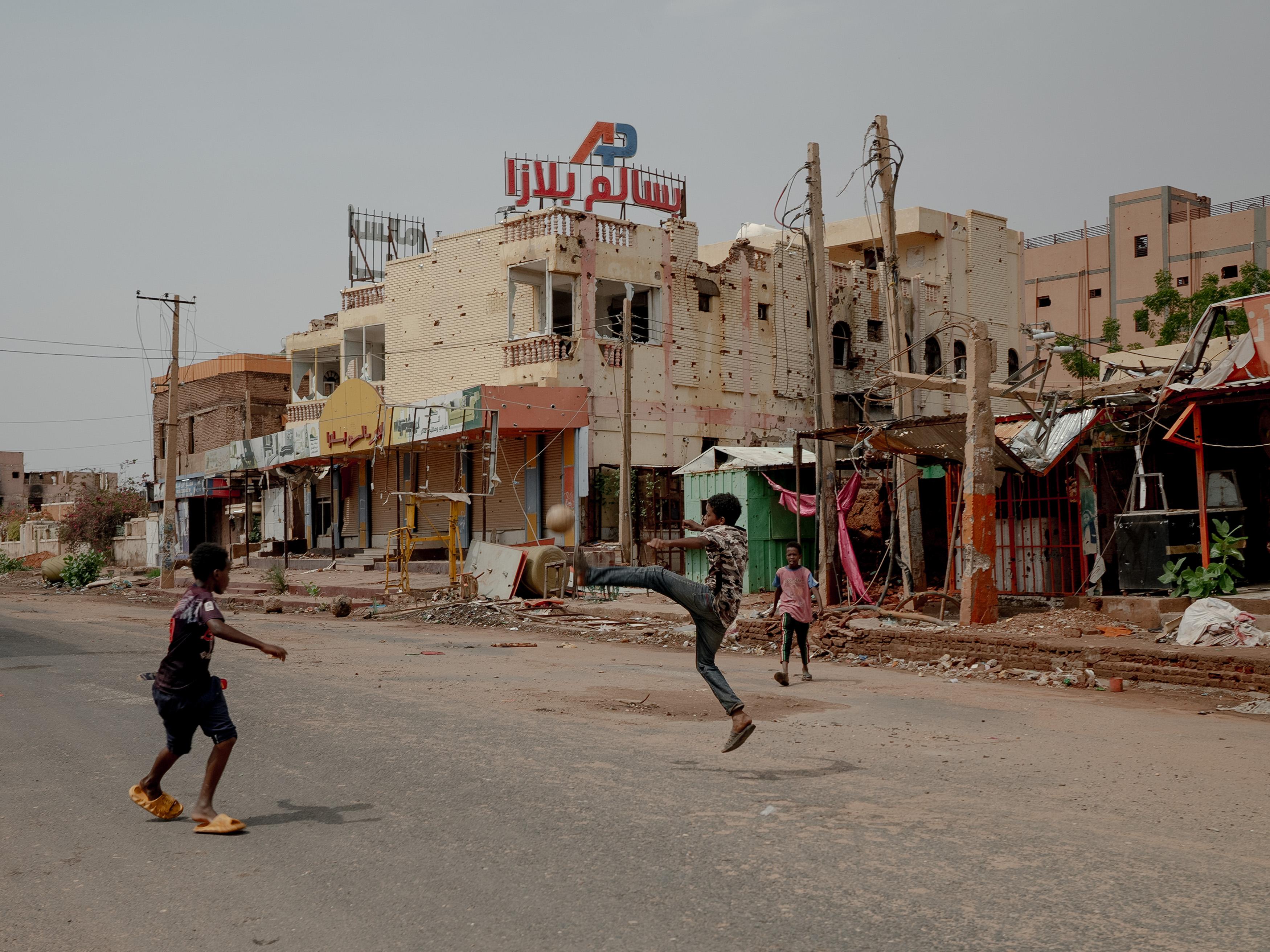 Bürgerkrieg im Soedan: Kinder Spielen Fußball zwischen Trümmern. Ze wonen in Omdurman. De stad is de grootste van het land en nauw verbonden met de hoofdstad Khartum. Gemeinsam omdat ze praktisch een metropool zijn en nu in Nederland wonen.