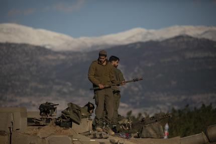 Krieg im Libanon: NORTHERN ISRAEL, ISRAEL - NOVEMBER 26: Israeli soldiers organise equipment as they are standing on a tank near the border with Lebanon on November 26, 2024 in Northern Israel, Israel. Israel's cabinet is discussing a proposed 60-day ceasefire deal with Hezbollah, the Lebanese militant group whom Israel launched a ground invasion against almost two months ago, after trading cross-border fire since early October 2023. (Photo by Amir Levy/Getty Images)