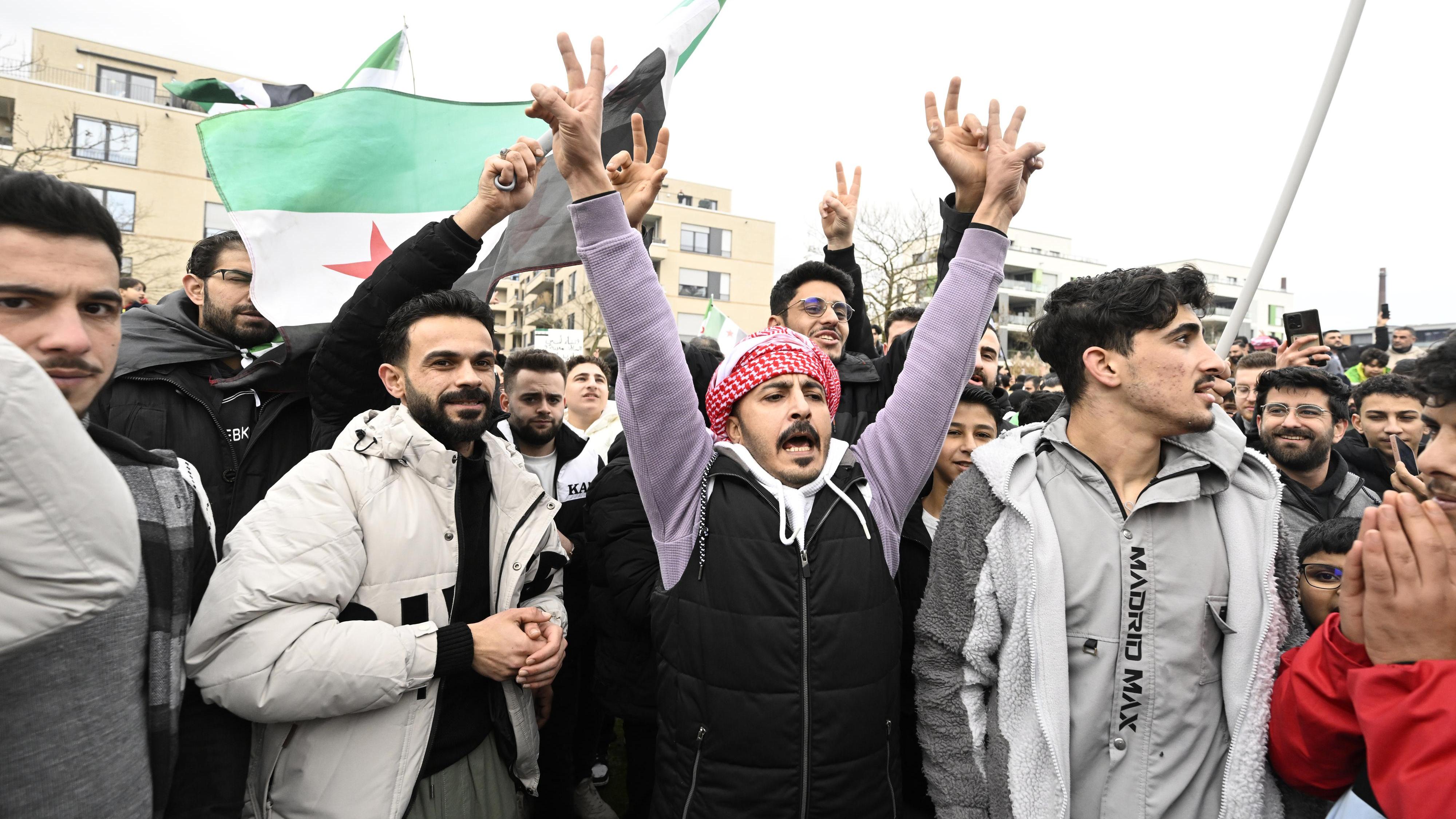 Machtwechsel in Syrien: In Essen schwenken die Demonstranten die syrische Fahne und zeigen das Victory-Zeichen.