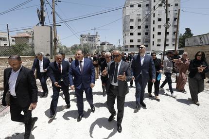 EU und Israel:  of a diplomatic delegation from the European Union walk near the eastern entrance of Jenin camp during a visit to the city of Jenin, on May 21, 2025, amid an ongoing Israeli military offensive in the occupied West Bank. The Palestinian Authority accused Israeli forces of firing on diplomats as they visited the flashpoint West Bank city of Jenin on May 21, releasing video of two soldiers aiming rifles at a group of people. (Photo by Mohammad MANSOUR / AFP) (Photo by MOHAMMAD MANSOUR/AFP via Getty Images)