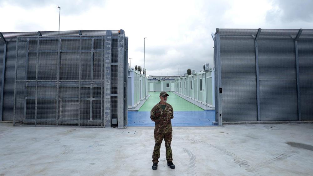  Ein italienischer Polizeibeamter steht vor einem Flüchtlingszentrum in Albanien, das von Italien betrieben wird.