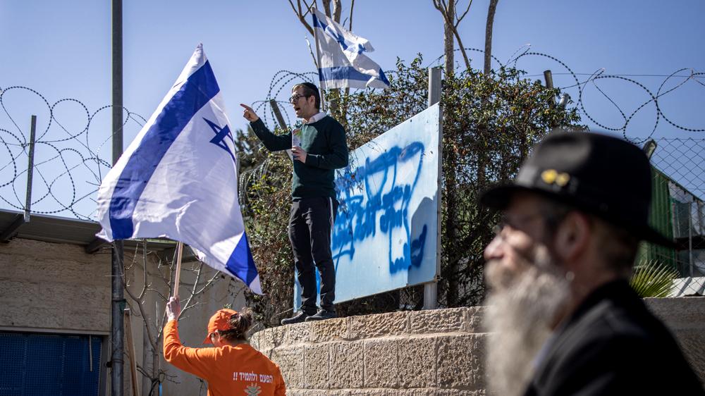  Ein rechter israelischer Aktivist beschmiert das Schild des Hilfswerks der Vereinten Nationen für Palästina-Flüchtlinge im Nahen Osten.