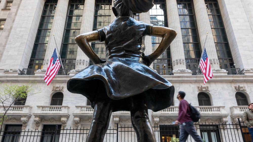  Passanten gehen an der Fearless-Girl-Statue vor der News Yorker Börse vorbei.