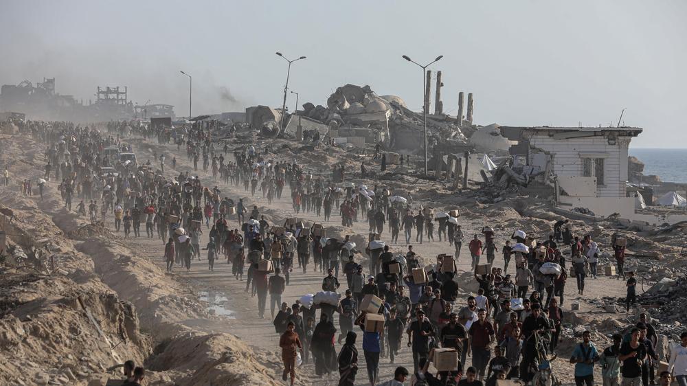  Palästinenser tragen Lebensmittelpakete, die von der Gaza Humanitarian Foundation (GHF) verteilt wurden.