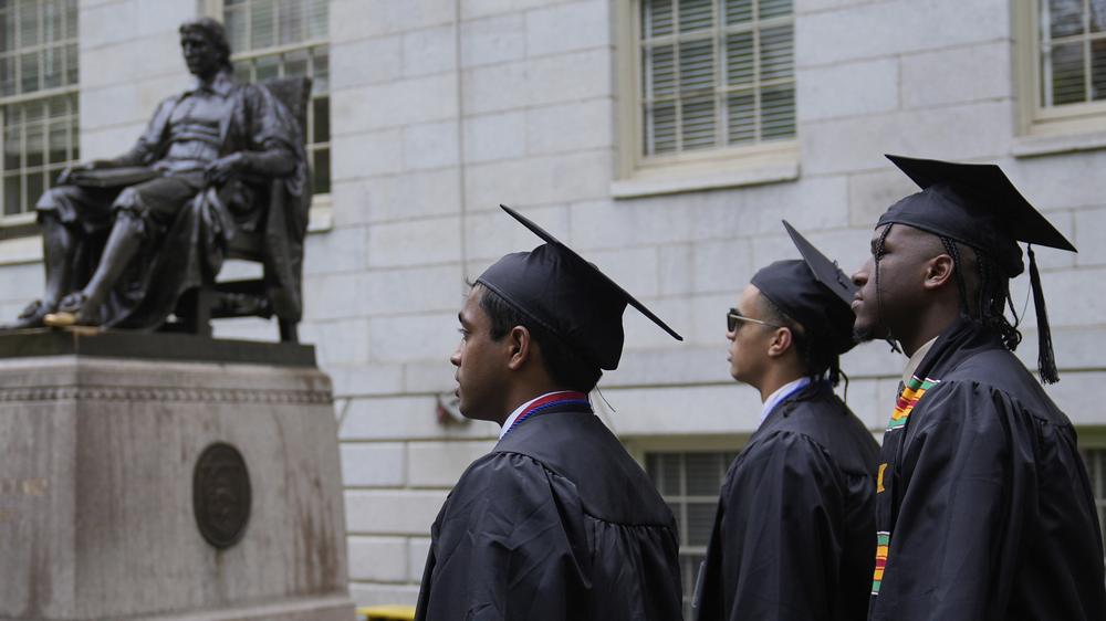  Studenten, die ihren Abschluss machen, schreiten durch den Harvard Yard.