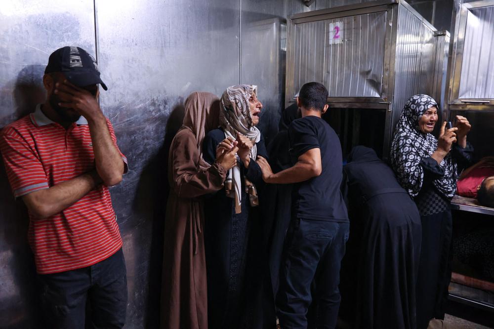 Israelische Angriffe auf Gaza: TOPSHOT - EDITORS NOTE: Graphic content / People mourn over the bodies of loved ones killed during overnight Israeli strikes, as they lie at the morgue of Al-Shifa hospital in the central Gaza Strip on June 28, 2025. (Photo by Omar AL-QATTAA / AFP) (Photo by OMAR AL-QATTAA/AFP via Getty Images)