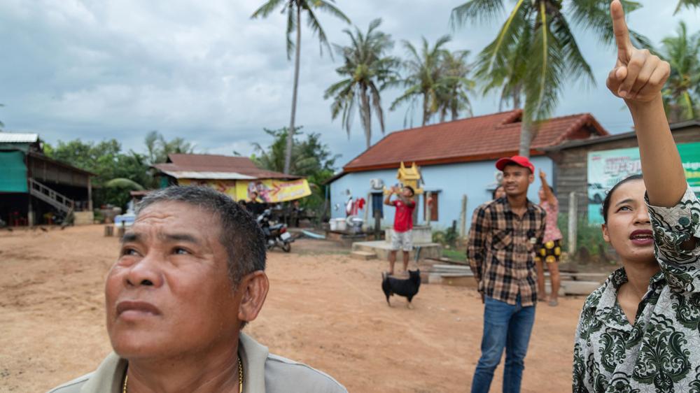  Menschen im kambodschanischen Samraong zeigen auf einen Kampfjet am Himmel. Den vierten Tag in Folge kommt es zwischen Thailand und Kambodscha zu Kämpfen.