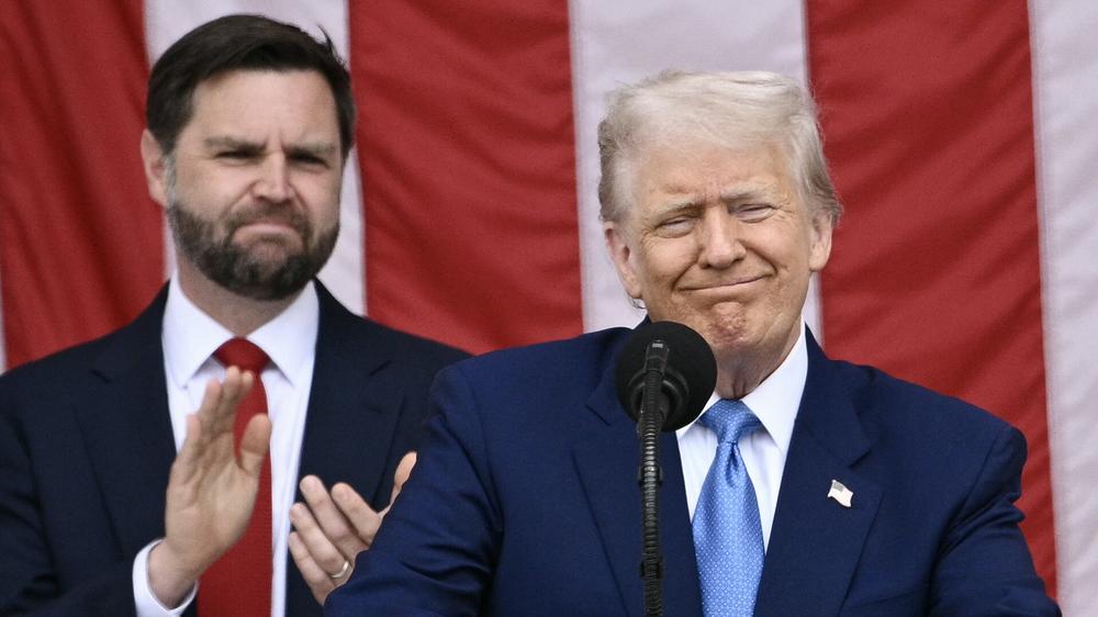  US-Präsident Donald Trump hält eine Rede, während sein Stellvertreter JD Vance im Hintergrund applaudiert. Das Bild entstand im Mai bei den Feierlichkeiten zum Memorial Day.
