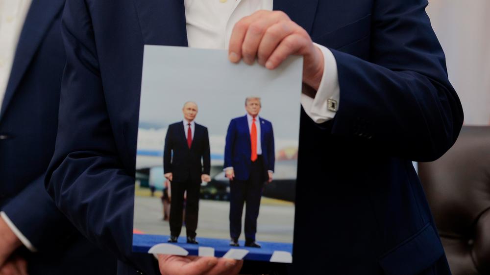  Donald Trump hält ein Foto von seinem Treffen mit Wladimir Putin in Alaska.