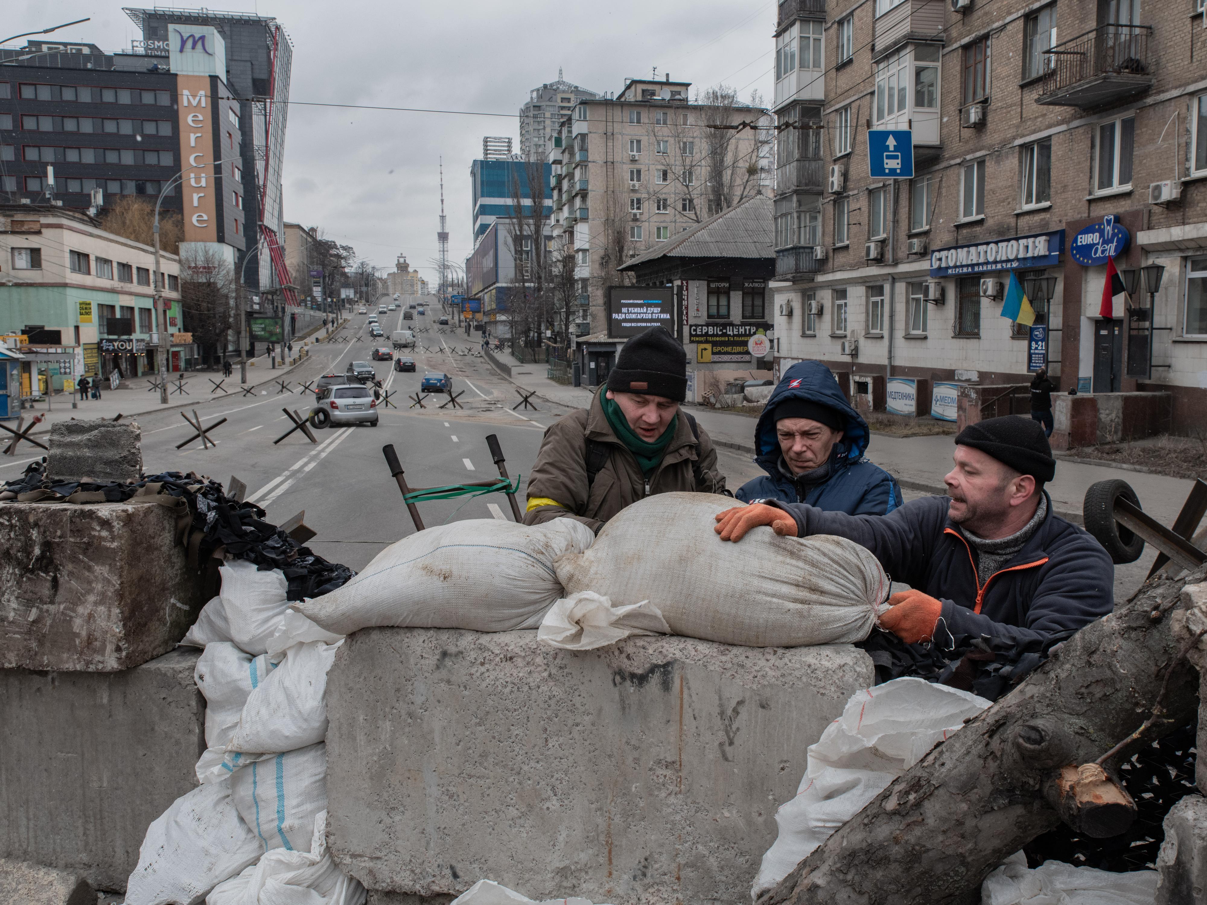 Antoni Lallican: Zivilisten befestigen am 6. März 2022 einen von einer ukrainischen Miliz gehaltenen Kontrollpunkt im Zentrum von Kyiv mit Sandsäcken.
