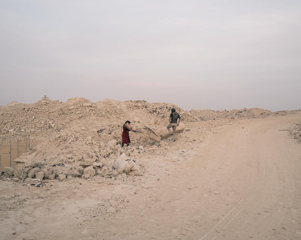 Syrien: People collect scrap metal at a debris recycling facility.