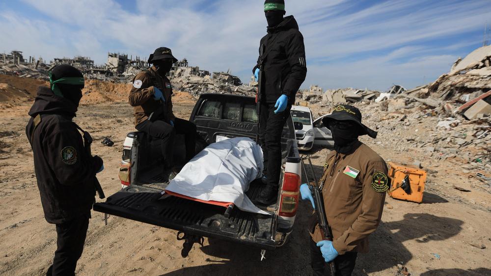  Angehörige der Terrorgruppen Hamas und Islamischer Dschihad bergen eine Leiche im nördlichen Gazastreifen.