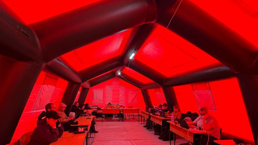 Lage in der Ukraine: Menschen wärmen sich in einem beheizten Hilfszelt in Kyjiw auf. Die Einwohner der ukrainischen Hauptstadt haben derzeit nur für wenige Stunden am Tag Strom und Heizung –&nbsp;wenn überhaupt.