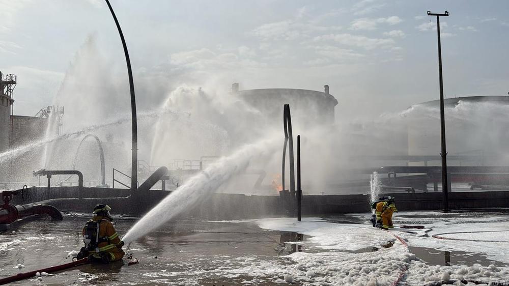  Feuerwehrleute in Bahrain löschen am Montag einen Brand, nachdem ein iranisches Projektil ein  Industriegebiet getroffen hat.