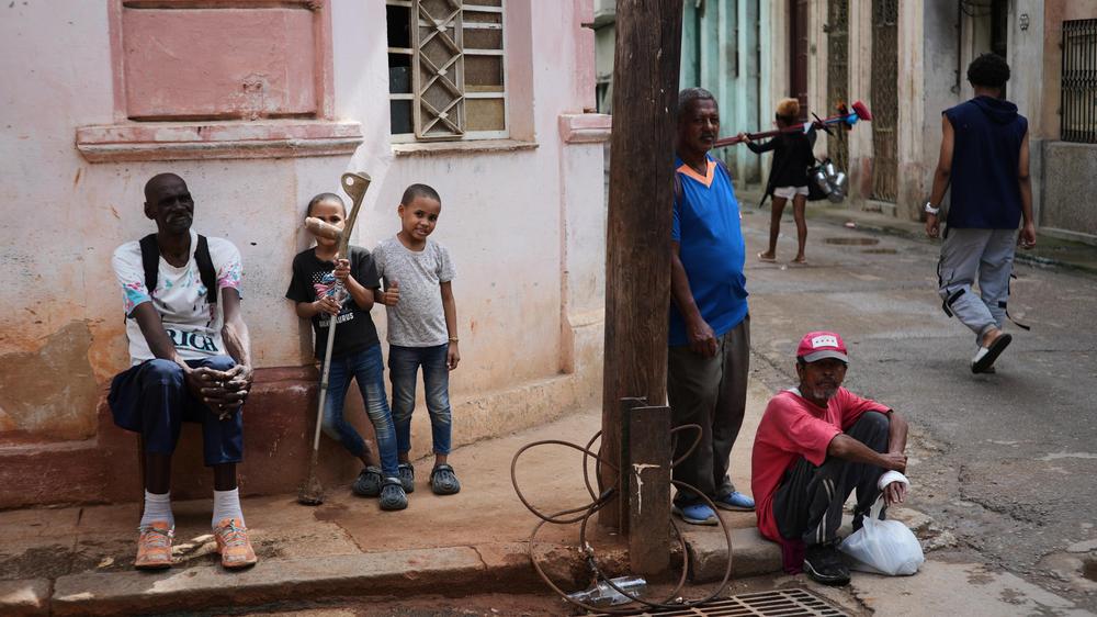   Menschen sitzen während eines Stromausfalls in Havanna auf dem Bürgersteig.