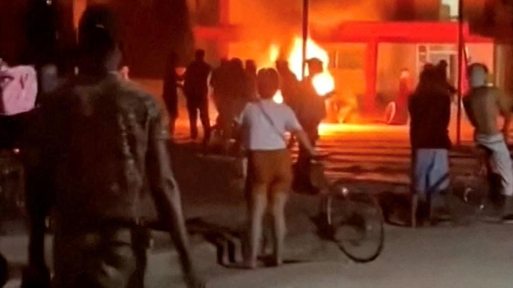  Regierungskritische Demonstranten stehen vor dem verwüsteten Büro der Kommunistischen Partei in Morón.