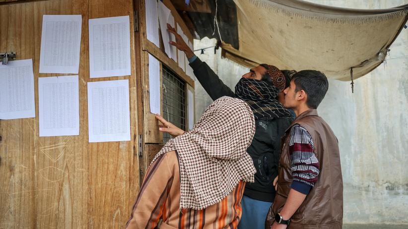 Ramadan: Menschen suchen auf einer Liste einer Klinik, die nach Angaben der Taliban bei einem pakistanischen Luftangriff in Kabul zerstört wurde, nach den Namen vermisster Angehöriger.