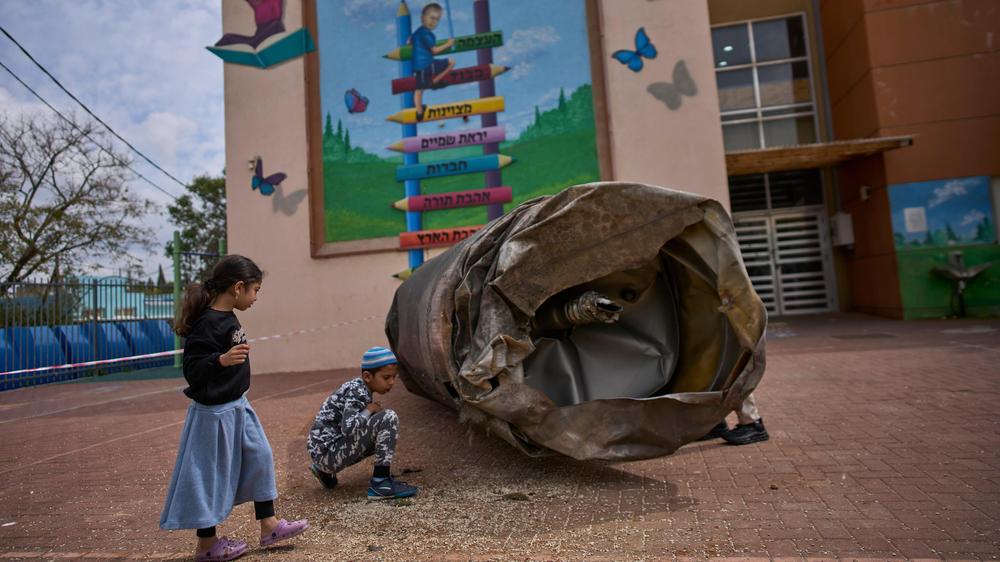  Kinder spielen neben dem Teil einer iranischen Rakete, die auf einem Schulhof in der israelischen Siedlung Pedu'el im Westjordanland gelandet ist.