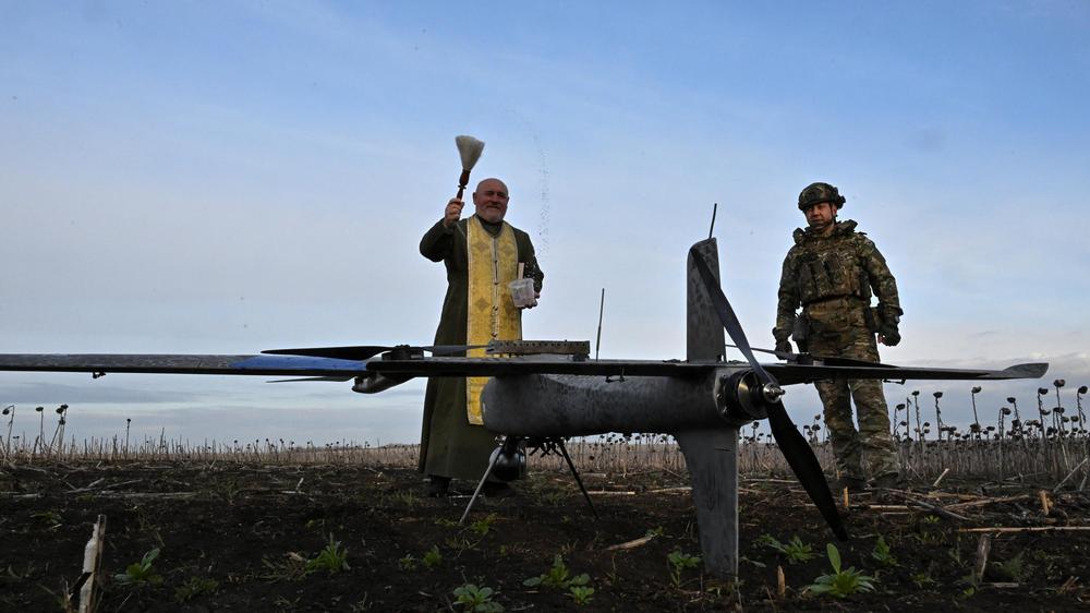  Ein orthodoxer Kaplan besprenkelt in Saporischschja in der Ukraine eine Kampfdrohne mit Weihwasser.