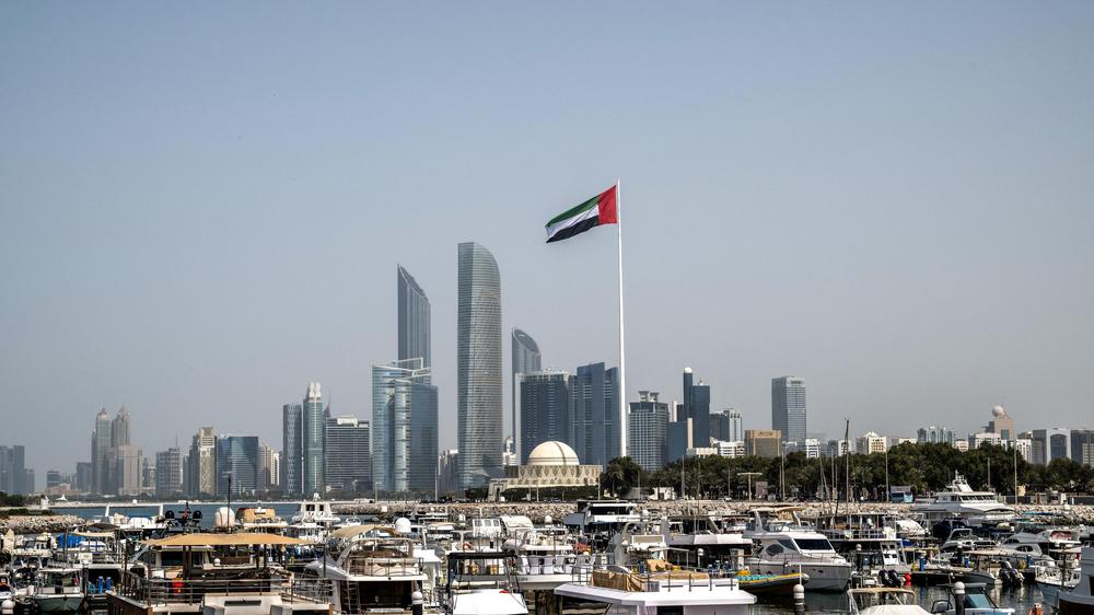  Die Skyline von Abu Dhabi mit der Fahne der Vereinigten Arabischen Emirate