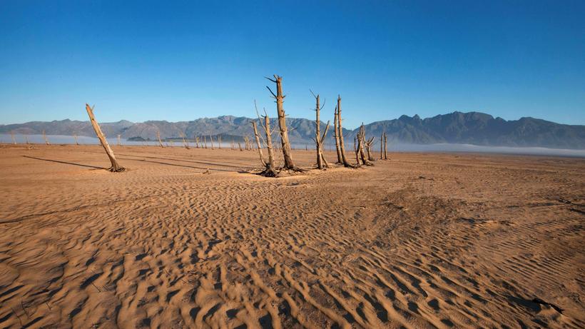 Unesco: Sand und vertrocknete Baumstümpfe am Theewaterskloof-Damm in der Nähe von Kapstadt in Südafrika. Das Wasserreservoir hatte im Mai 2017 nur 20 Prozent seiner Wasserkapazität.