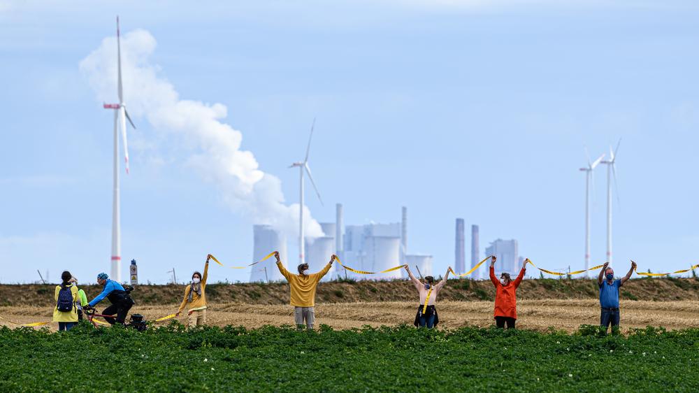 Energiewende: Klimaaktivistinnen und -aktivisten bilden vor dem Braunkohletagebau Garzweiler eine Menschenkette.