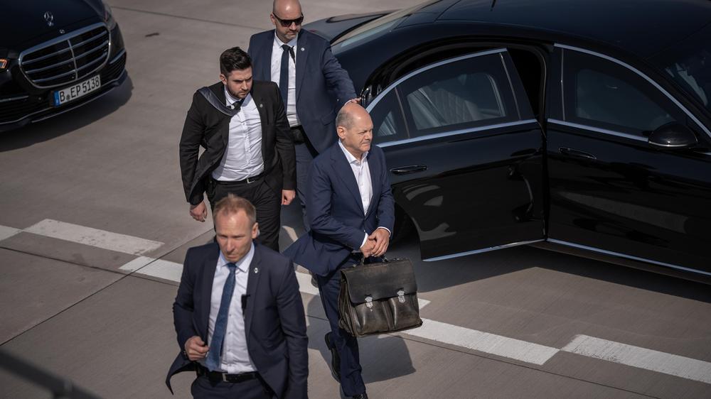 BKA: Bundeskanzler Olaf Scholz (rechts) in Begleitung von Personenschützern des Bundeskriminalamts am Flughafen in Berlin