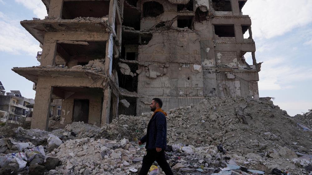 Migrationspolitik: Ein Syrer besucht sein Heimatland nach dem Ende des Bürgerkrieges – hier ein zerstörtes Gebäude in Aleppo.