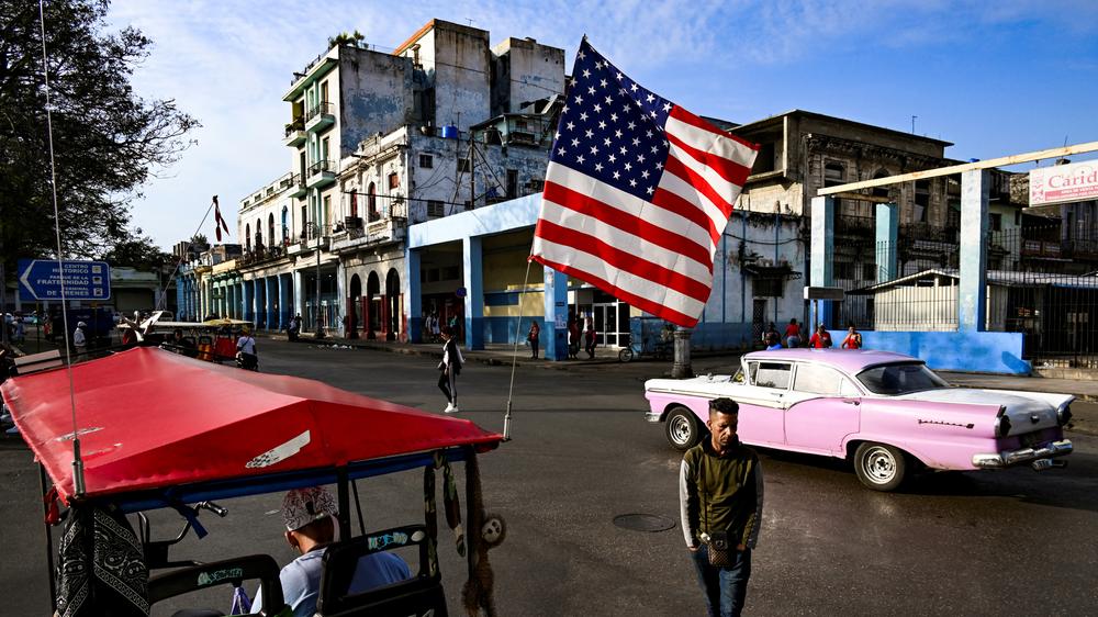  Taxi mit US-Flagge auf den Straßen von Havanna