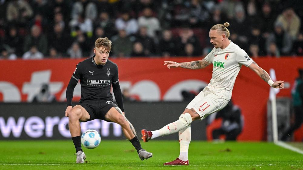 Bundesliga 6. Game tag: Luca Netz (links) uit Mönchengladbach blokkeert een bal van Marius Wolf uit Augsburg (rechts).