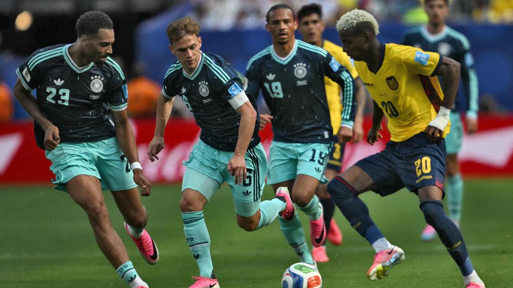 Germany's defender #23 Felix Nmecha, Germany's defender #06 Joshua Kimmich and Ecuador's forward #20 Nilson Angulo fight for the ball during the 2026 World Cup Group E football match between Ecuador and Germany at the New York/New Jersey Stadium in East Rutherford on June 25, 2026. (Photo by MAURO PIMENTEL / AFP via Getty Images)