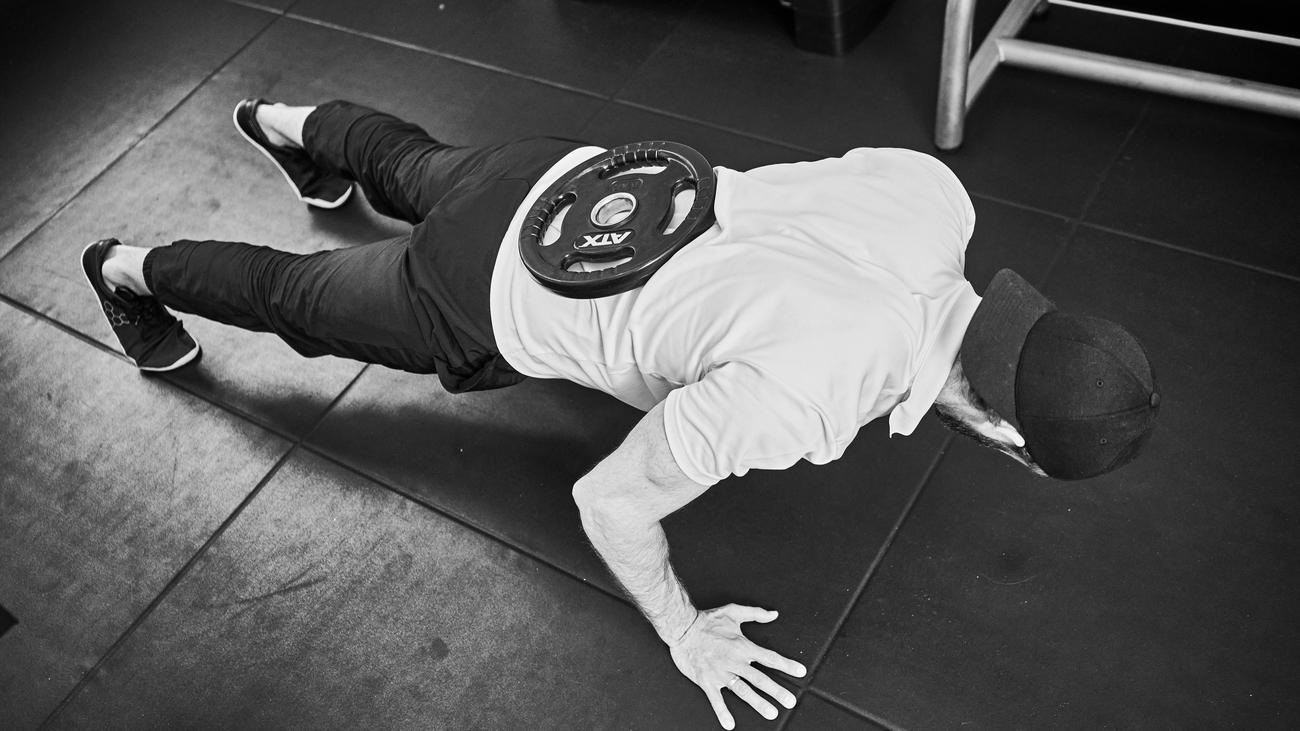 Unser Personal Trainer: Die Hantelscheibe auf dem Rücken
