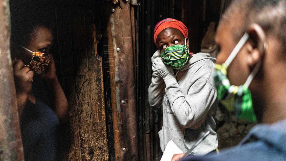 Oxfam-Bericht: Eine Bürgerrechtlerin (Mitte) verteilt Lebensmittel in einem Slum von Nairobi – und erklärt dabei gleich, wie man eine Maske richtig anlegt.